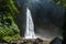 Adventure seeker standing near the beautiful jungle waterfall