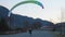 Adventure Seeking Person Flying a Paraglider during a sunny sunset in spring time.