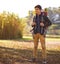 On an adventure. Shot of a young boy wearing a backpack in nature.