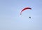 Adventure sport paragliding on a summer day with clear blue sky.