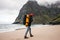 Adventure traveler with backpack hiking by ocean sand