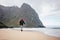 Adventure traveler with backpack hiking by ocean sand