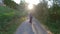 Adventure Woman bike riding on a bicycle trail surrounded by green trees.