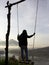 Adventure woman standing on natural wooden swing, enjoying misty mourning view in the morning. Person relax on swing.