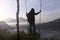 Adventure woman standing on natural wooden swing, enjoying misty mourning view in the mountain.