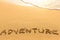 Adventure - word drawn on the sand beach