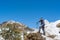 Adventurer climber standing snowy trail with hiking poles at the mountains