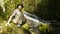 Adventurer sitting next to a waterfall