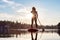 Adventurous Caucasian Adult Woman Paddling on a Stand up Paddle Board