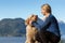 Adventurous Girl Hiking on top of a Mountain with a dog