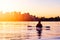 Adventurous Girl Sea Kayaking during a vibrant winter sunrise