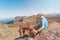 Adventurous Hiker and his hungarian vizsla dog are taking a rest at the top of the mountain drinking water