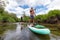 Adventurous Hispanic Athletic Man and Caucasian Woman paddle boarding