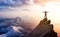 Adventurous Man Hiker With Hands Up on top of a Steep Rocky Cliff