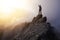 Adventurous Man Hiker With Hands Up on top of a Steep Rocky Cliff.