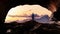 Adventurous Man Hiker standing in a cave with dramatic cloud and snowy mountain view