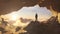 Adventurous Man Hiker standing in a cave with rocky mountains