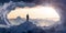 Adventurous Man Hiker standing in an Ice Cave with rocky mountains in background.