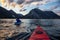 Adventurous Man Kayaking in Glacier Lake surrounded by the beautiful Canadian Rocky Mountains