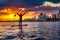 Adventurous man is paddle boarding near Downtown City