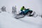 Adventurous Man Riding a Snowmobile in white snow