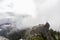 Adventurous Man Standing on top of a rugged rocky mountain