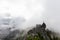 Adventurous Man Standing on top of a rugged rocky mountain