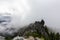 Adventurous Man Standing on top of a rugged rocky mountain