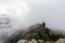 Adventurous Man Standing on top of a rugged rocky mountain