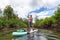 Adventurous people paddle boarding in a river