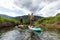 Adventurous people paddle boarding in a river