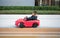 Adventurous Toddler Drives Red Sports Car with Joyful Glee