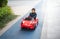 Adventurous Toddler Drives Red Sports Car with Joyful Glee