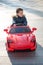 Adventurous Toddler Drives Red Sports Car with Joyful Glee