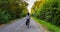 Adventurous White Cacasusian Woman riding a bicycle on a road.