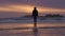 Adventurous woman standing on the sandy beach on the west coast of Pacific Ocean