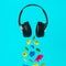 Advertisement idea with black music headphones, colorful summer flowers and green leaves against pastel blue background. Minimal