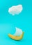 Advertisement idea with a cloud, yellow banana like a ship and a sail of paper against pastel blue background. Minimal summer