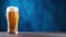 Advertising shot, banner, a glass of light beer with foam isolated on a dark blue background