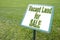 Advertising signboard with Vacant Land for Sale written on it against a green meadow - concept image
