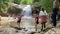 Adygea, Russia, July 2021, people in summer clothes walk carefully across river