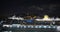 Aeial view. Big cruise ship with lighted lights stands in the port at night.