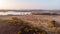 An aerail view of the Studland Nature Reserve with sand dune, peat bog and lake under a majestic hazy blue sky