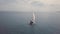 Aerial 4K footage of luxury catamaran yacht with white and red sail in blue seas