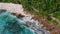 Aerial 4K view of beautiful exotic tropical beach at Mahe island, Seychelles. Ocean waves and blue lagoon and coconut