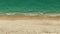 Aerial above view of empty sandy beach and ocean with waves