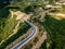 Aerial above view of a rural landscape with a curvy road running through it in Greece.