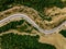 Aerial above view of a rural landscape with a curvy road running through it in Greece.