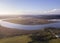 Aerial above a winding river in a wetland at sunrise