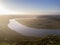 Aerial above a winding river in a wetland at sunrise